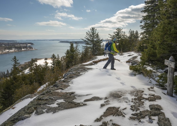 Jayme Rec leaves the summit of Flying Mountain in Acadia National Park. The trail up to the summit of Flying Mountain above Somes Sound was untracked and required some careful route finding with some of the trail blazes on rocks covered by snow. Parts of the trail were completely covered in ice and required traction aid footwear like the Yaxtrax.