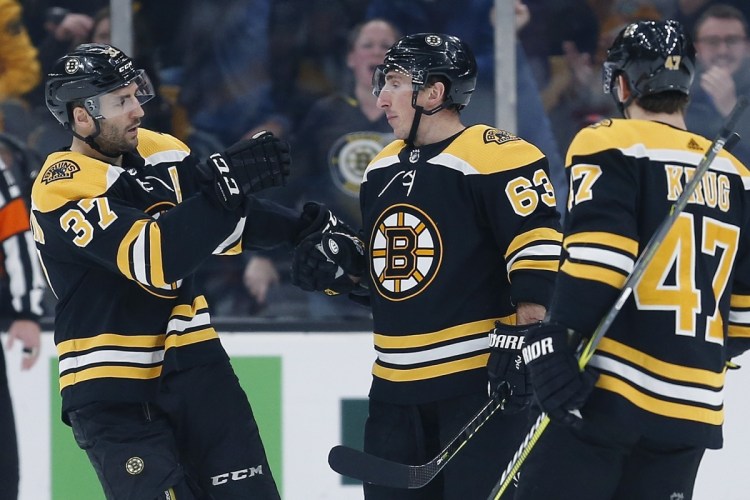 Boston's Brad Marchand celebrates his goal with teammates Patrice Bergeron, left, and Torey Krug during the Bruins' 1-0 win over the New Jersey Devils on Saturday in Boston.