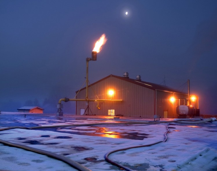 Unused methane gas, not consumed by Qualco's powerhouse, flames off a giant stack outside the facility near Monroe, Wash., in 2012. 