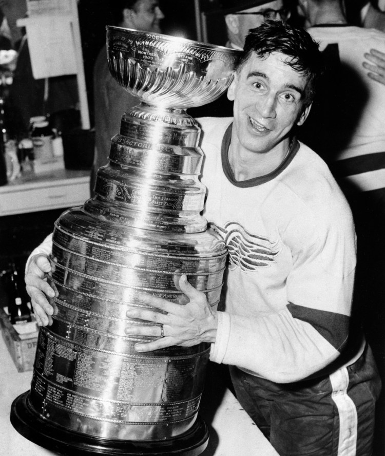 In this April 16, 1954, file photo, Detroit Red Wings captain Ted Lindsay hugs the Stanley Cup after his team defeated the Montreal Canadiens, 4-3, in a sudden death extra period to win the Stanley Cup Final.