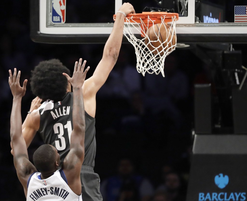 Brooklyn's Jarrett Allen dunks while being defended by Dallas' Dorian Finney-Smith during the Nets' 127-88 win Monday at New York.