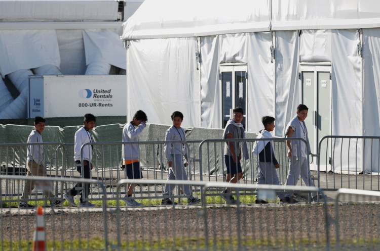 Immigrant children line up outside a tent at a shelter in Florida last month. Migrants continue to push toward the Mexican border in record numbers. "The system is well beyond capacity," a border security official said Tuesday.
