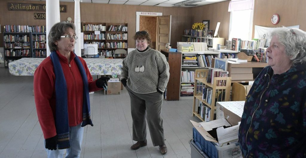 Staff photo by Andy Molloy
Cheryl Joslyn, left, and another library volunteer confer Tuesday in Whitefield's library, located in the former Arlington Grange. The library hopes to acquire the structure to sprovide the library a permanent location.