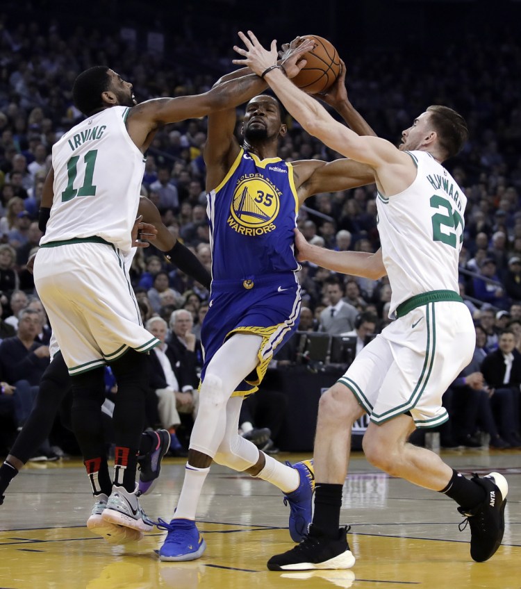 Boston's Kyrie Irving and Gordon Hayward defend against Golden State's Kevin Durant during the first half Tuesday night in Oakland, Calif.