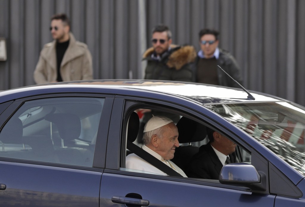 Pope Francis waves as he leaves St. John Lateran Basilica after meeting clergy members in Rome on Thursday.