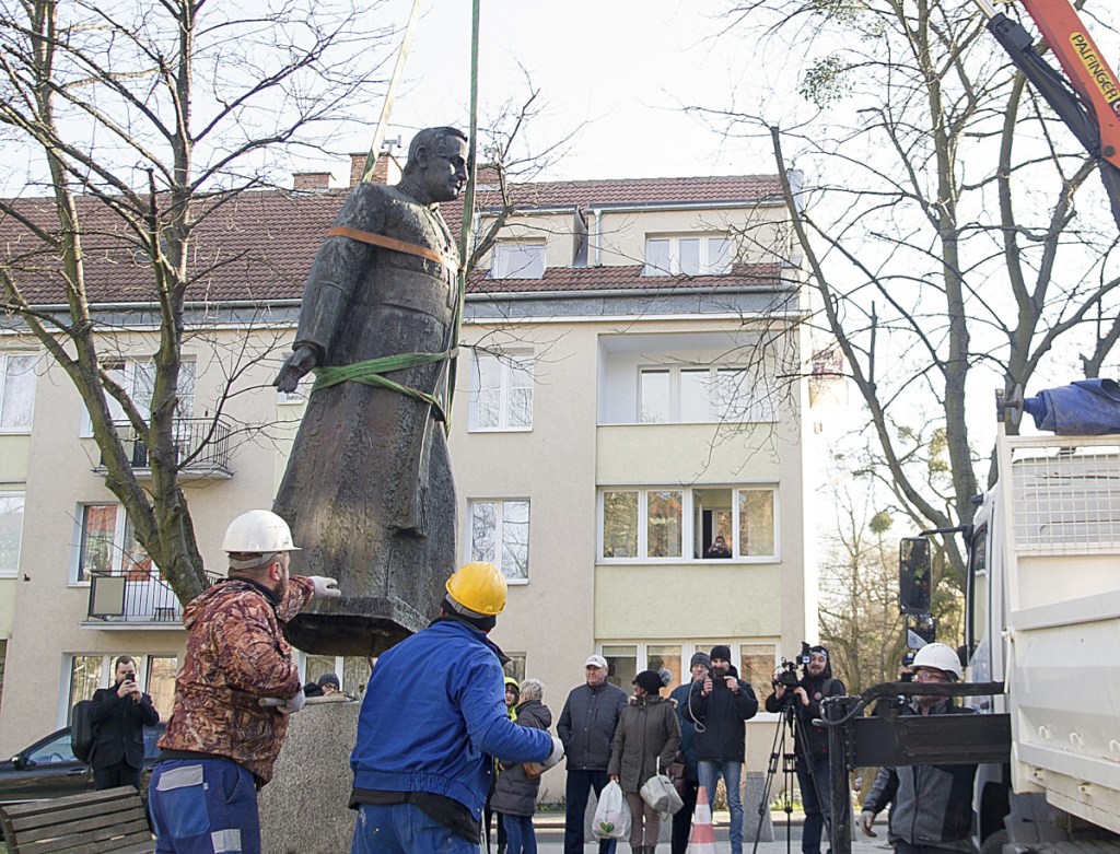 Workers dismantle a statue of the late Solidarity-era priest Henryk Jankowski in Gdansk, Poland, on Friday. City councilors decided to remove it amid allegations Jankowski sexually abused minors.