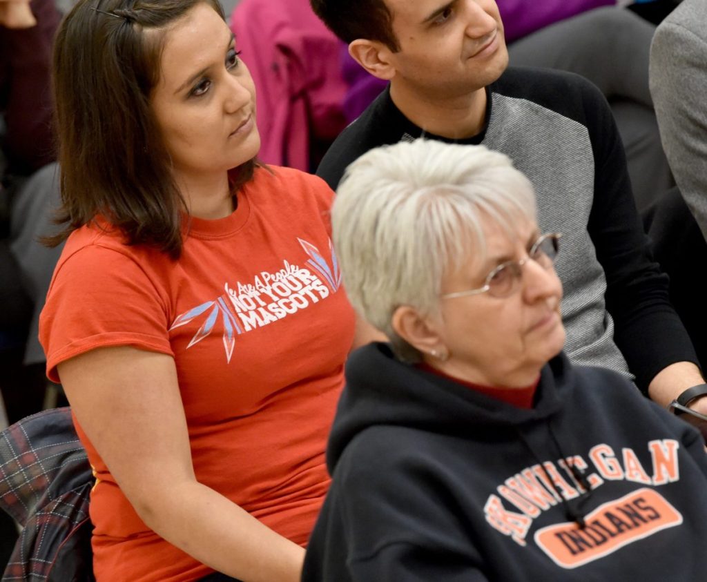 Malian Dana of Indian Island, back left, sits with a shirt that reads "We Are A People Not Your Mascot" during a school board meeting at Skowhegan Middle School in 2016.