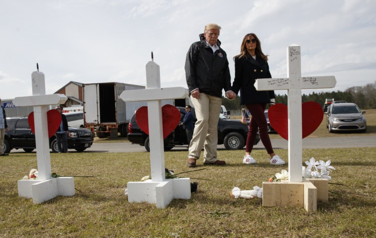 President Trump and first lady Melania Trump view a line of crosses at Providence Baptist Church in Smiths Station, Ala., on Friday as they tour areas where tornadoes killed 23 people last weekend.
