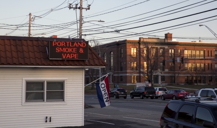 Portland Smoke & Vape shop at 585 Broadway, in the foreground, sits across the street from Daniel F. Mahoney Middle School, in the background, in South Portland.