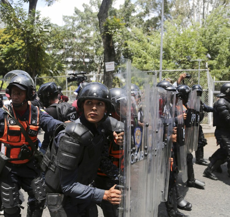 A cordon of Venezuelan National Police officers retreats when confronted by demonstrators who were temporarily blocked by police from getting to a rally against the government of President Nicolas Maduro in Caracas on Saturday.