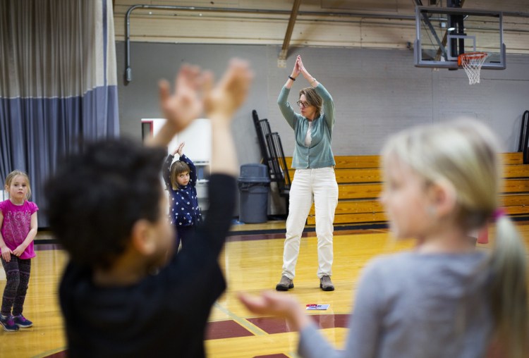 Education technician Kathy Robbins leads Saco Community Center pre-kindergartners in a yoga exercise Thursday. Saco and Portland are among school districts planning to apply increased subsidies to expanded pre-K programs.
