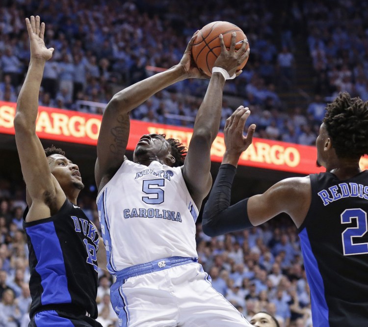Nassir Little of North Carolina drives to the basket Saturday night between Javin DeLaurier, left, and Cam Reddish of Duke during the first half of their Atlantic Coast Conference men's basketball game. North Carolina won, 79-70.
