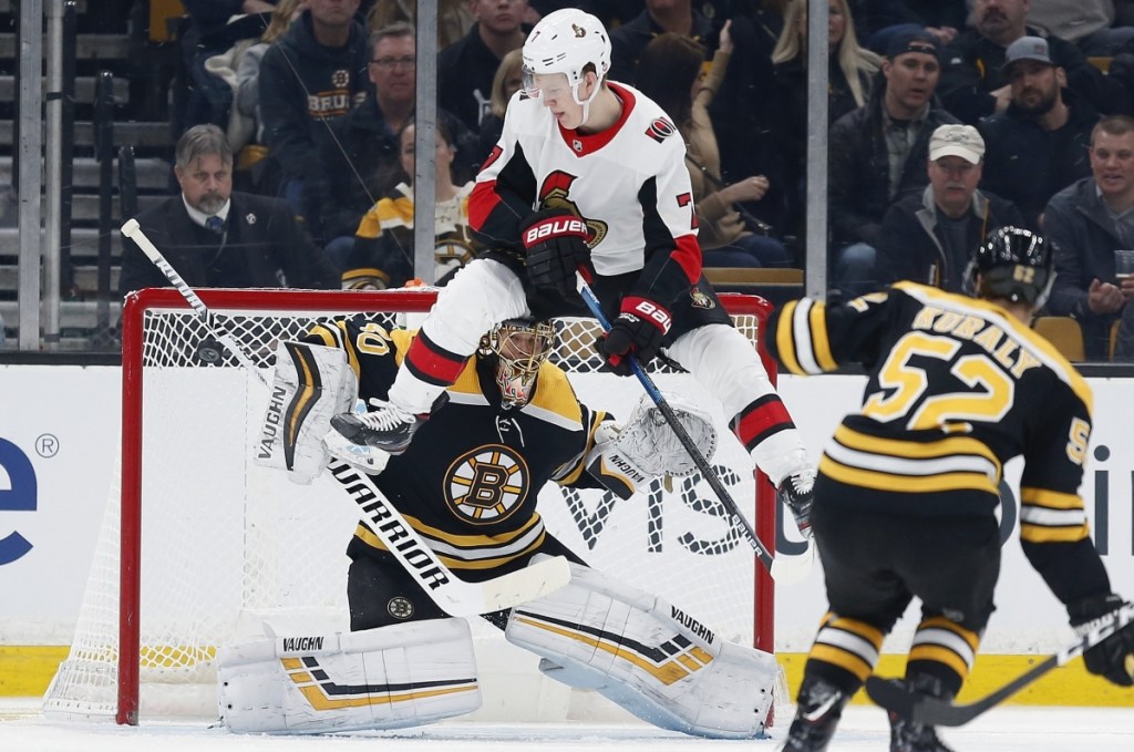 Ottawa's Brady Tkachuk jumps in front of Bruins goalie Tuukka Rask to avoid a shot by teammate Thomas Chabot during Boston's 3-2 win Saturday night at TD Garden.