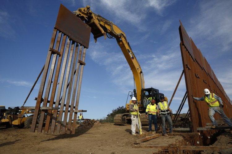 Construction crews install new border wall sections, seen from Tijuana, Mexico. Officials say President Trump is asking Congress for $8.1 billion for his dream project in his budget proposal to be unveiled Monday.