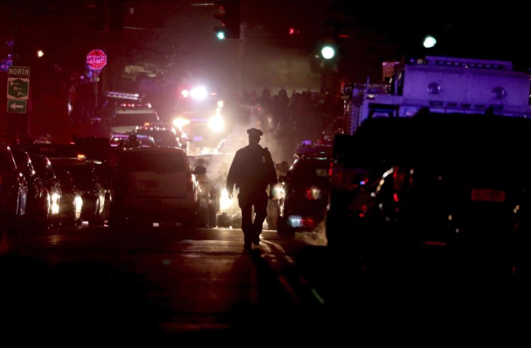 An officer walks the street as authorities from various local departments surround Lawrence Hospital in Bronxville, N.Y., late Sunday night as police searched inside the hospital for a possible gunman. All local roads around the hospital were closed as heavily armed police swarmed the area.