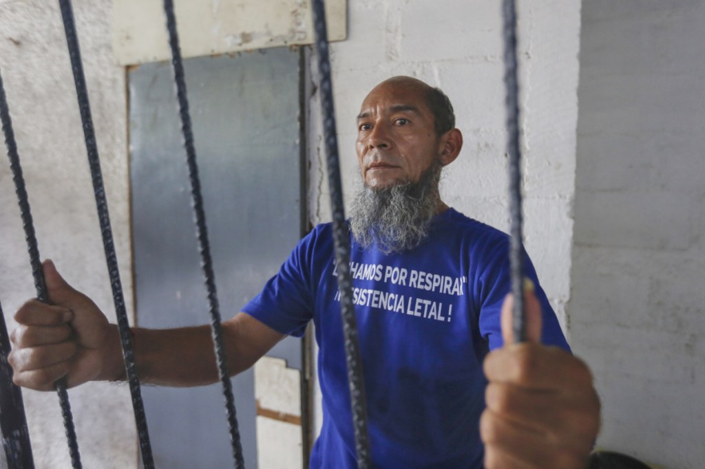 Last week, Alex Vanegas holds on to the iron bars he had installed on the porch of his apartment in Managua, Nicaragua, to symbolize his house arrest.