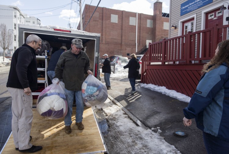 Ron Paquin helps bring winter coats, toiletries and other goods donated by churches in Maine, New Hampshire and Massachusetts into the Portland Family Shelter on Monday.