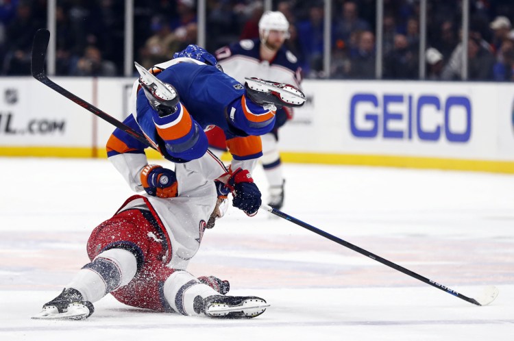 Islanders center Valtteri Filppula, top, trips over Blue Jackets left wing Nick Foligno during the first period Monday at Uniondale, N.Y. The Islanders won, 2-0.
