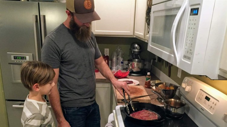 Nate Lindskoog and his son Jett cook up venison tacos in their Nampa, Idaho, home. The deer was killed by a car a year earlier.