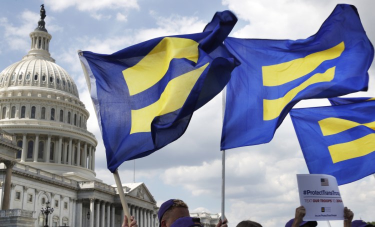 People with the Human Rights Campaign hold up "equality flags" during an event in support of transgender members of the military on Capitol Hill in Washington in 2017. Congress will soon consider a comprehensive LGBT nondiscrimination bill, but it could well be doomed by lack of Republican support.