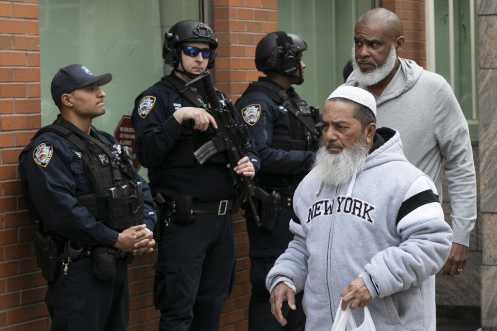 Men leave the Islamic Cultural Center of New York under increased police security Friday following the deadly attacks on mosques in New Zealand.