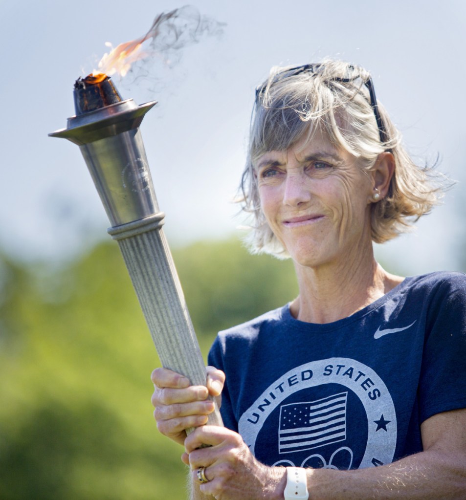 Joan Benoit Samuelson carries a torch during opening ceremonies for the TD Beach to Beacon High School Mile in August 2016. (Photo by Derek Davis/Staff Photographer)