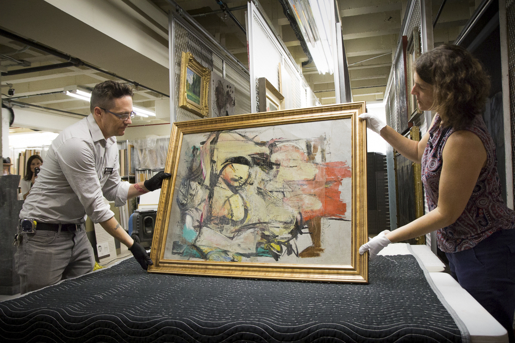 In August 2017, "Woman-Ochre," a painting by Willem de Kooning, is readied for examination by University of Arizona Museum of Art staff members Nathan Saxton and Kristen Schmidt in Tucson.