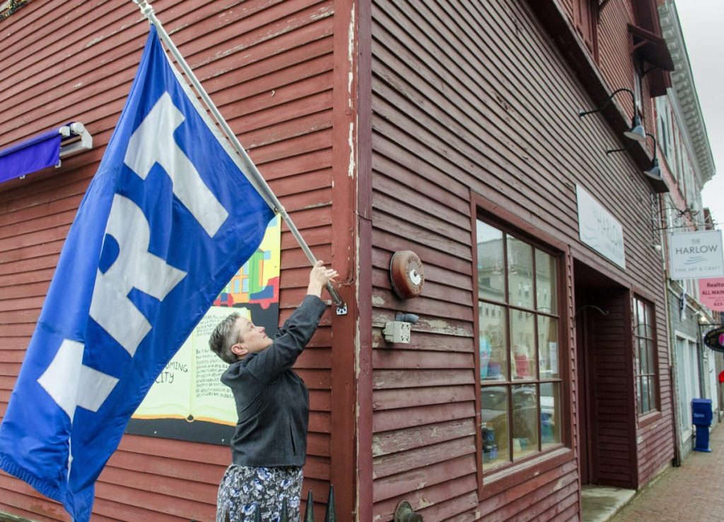 Kennebec Journal photo by Joe Phelan
Executive director Deb Fahy puts out a large flag that says ART just before opening up at noon Friday at the Harlow Gallery on Water Street in Hallowell. Fahy is stepping down after 14 years as director.