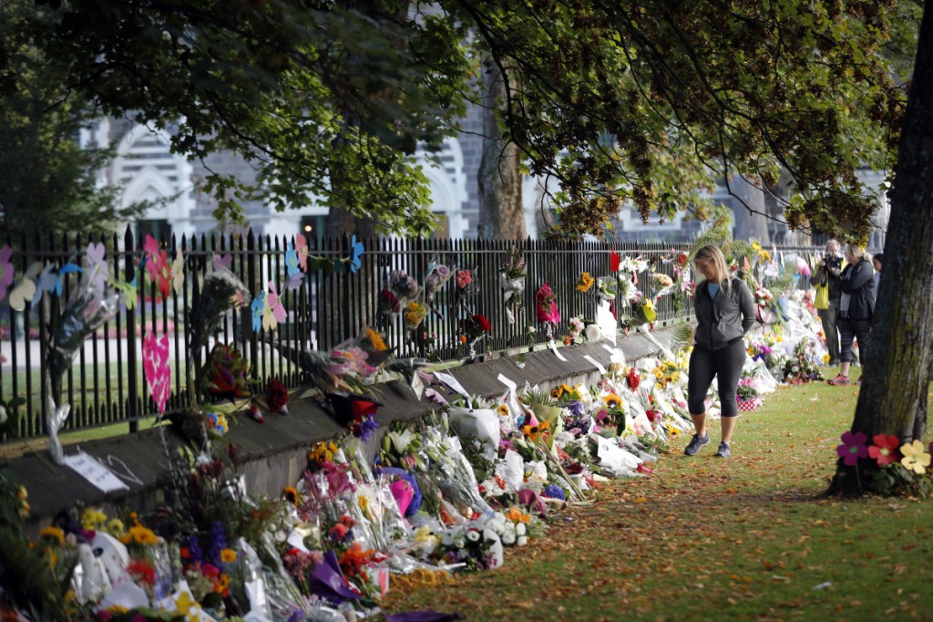 Mourners pay their respects at a makeshift memorial at the Botanical Gardens in Christchurch, New Zealand, Saturday. Brenton Tarrant is suspected of killing 49 people at two mosques.