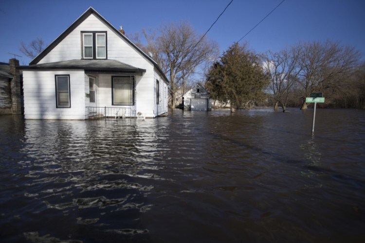 Floodwaters lap close to the front yards of homes on South Sherman Avenue in Freeport, Ill., on Friday. Rising waters along the Pecatonica and Rock rivers have flooded homes in northern Illinois.
