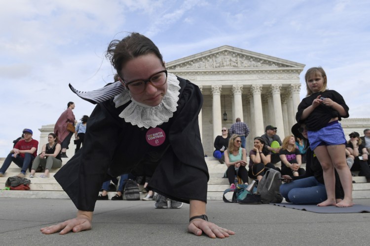 Alice Wisbiski, dressed as Supreme Court Associate Justice Ruth Bader Ginsburg, exercises on the steps of the Supreme Court in Washington on Friday, to celebrate Ginsburg's 86th birthday.