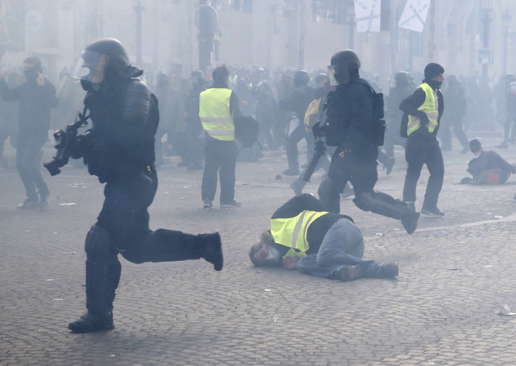 Riot police charge through a yellow vests demonstration in Paris on Saturday. Protesters say President Emmanuel Macron failed to respond to citizens' concerns about sinking living standards, stagnant wages and high unemployment. "We're here to show Macron that empty words are not enough," said yellow vest demonstrator Frank Leblanc, 62.