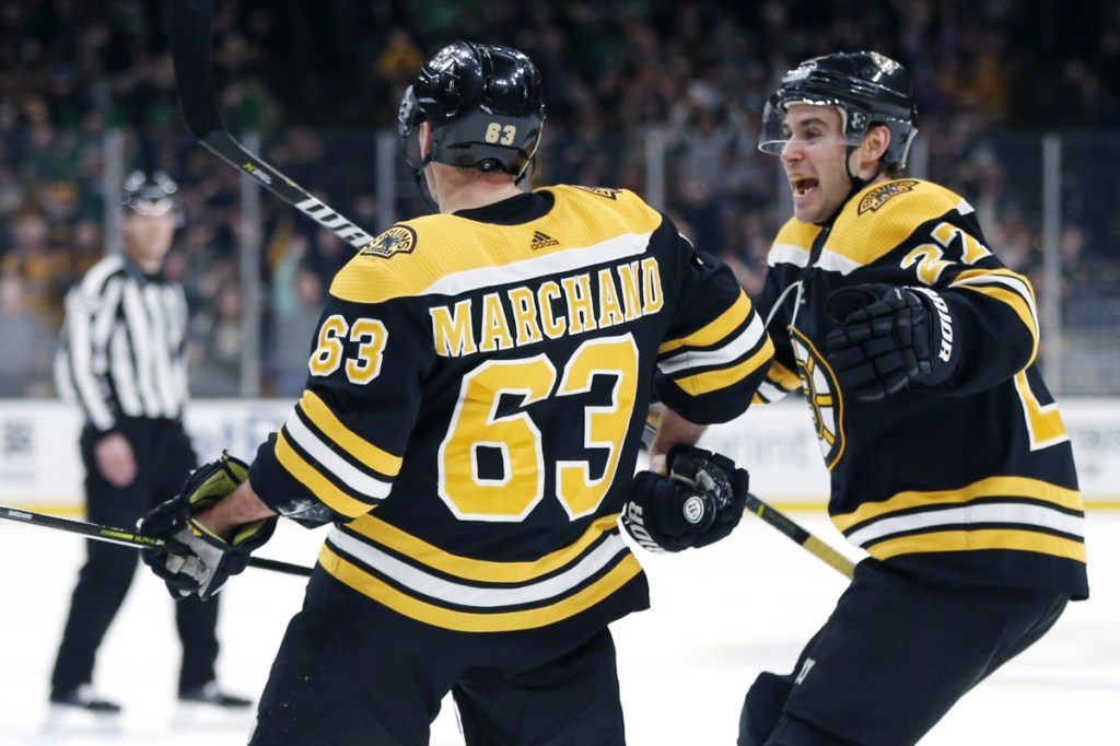 Brad Marchand, left, celebrates with John Moore after scoring in overtime Saturday night to give the Bruins a 2-1 win over the Columbus Blue Jackets.