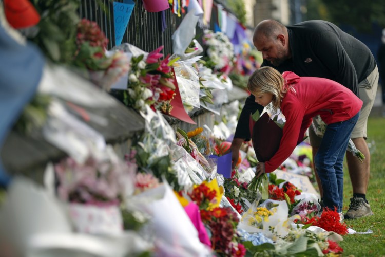 Mourners lay flowers on a wall at the Botanical Gardens in Christchurch, New Zealand, on Saturday.