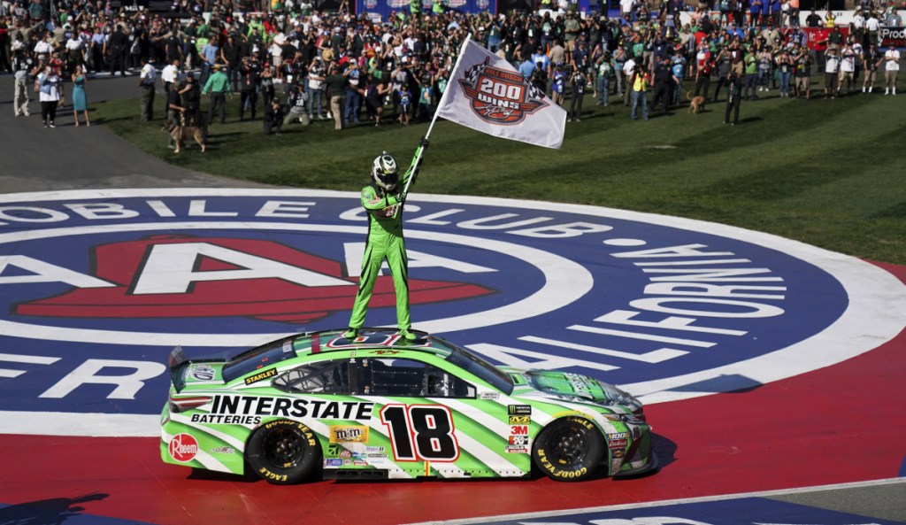 Kyle Busch stands atop his car Sunday after winning the NASCAR Cup Series race at Auto Club Speedway in Fontana, Calif. – his 200th victory across NASCAR's three national series. "Feels just like No. 1," Busch said.