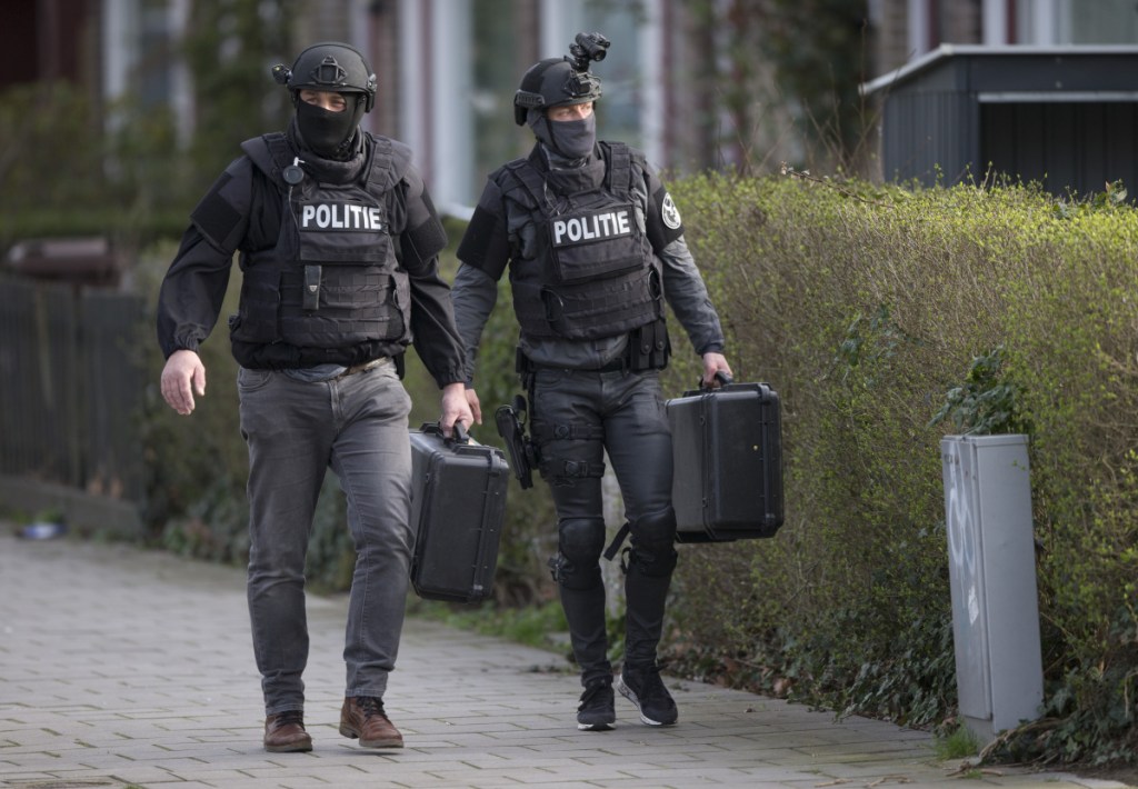 Dutch counterterrorism police leave after searching a house following the shooting incident Monday on a tram in Utrecht, Netherlands.