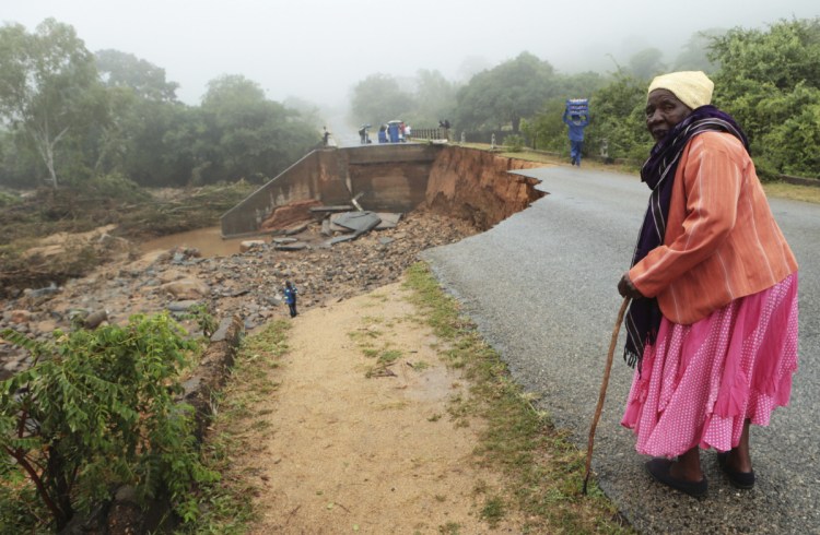 An elderly woman stands next to a collapsed bridge in Chimanimani, Zimbabwe, on Monday.