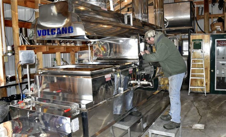   Maple syrup producer Jim Steeves peers into his evaporator Tuesday in preparation for another boil at his Smith Brothers Maple Syrup Products operation in Skowhegan. Smith said the sap was running and he made 60 gallons of syrup last Sunday. He is taking part in the annual Skowhegan Maple Fest, which begins this Friday and runs through Sunday, which is Maple Syrup Sunday.