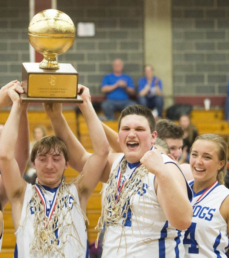 Madison's Scott Sawtelle, left, hoists the Gold Ball after scoring 40 points in dethroning Westbrook 58-54 for the Unified title.