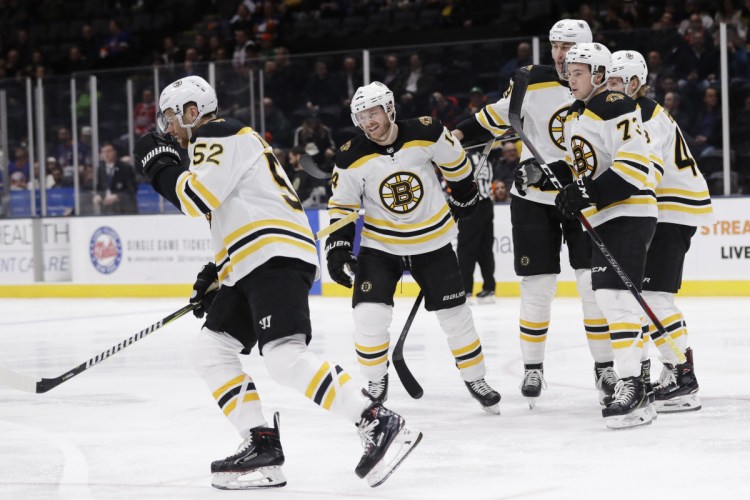 Boston's Sean Kuraly skates back to his bench with teammates after scoring a goal in the first period Tuesday night at Uniondale, N.Y.