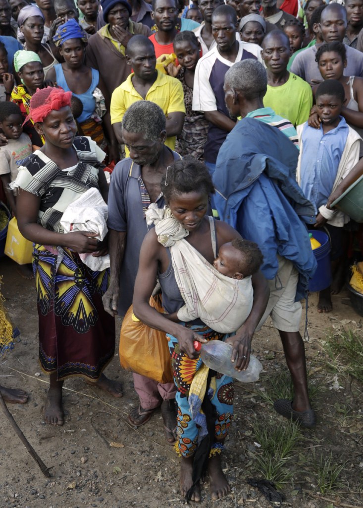A group of refugees waits to receive food from the World Food Programme in Nhamatanda, about 30 miles west of Beira, Mozambique, on Thursday.