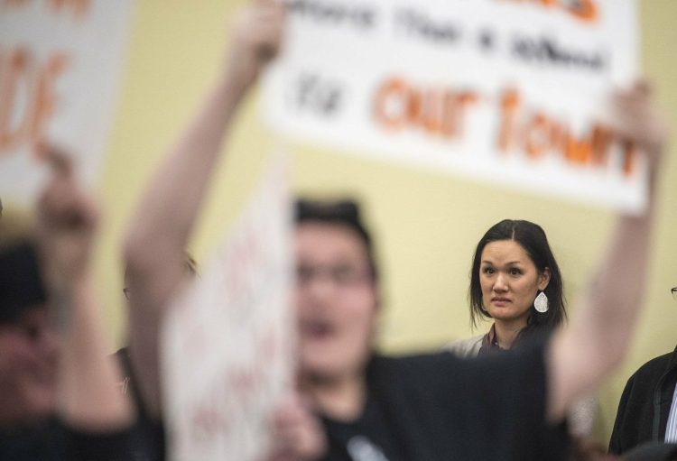 A woman listens Thursday as a majority of people at a school board meeting at Skowhegan Middle School cheer for the "Indians" sports teams nickname.