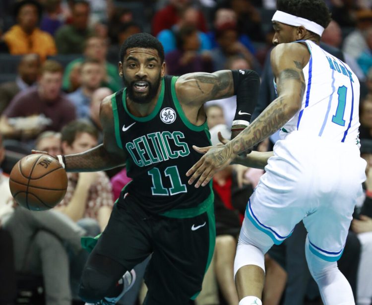 Celtics guard Kyrie Irving moves past Charlotte's Mailik Monk during Boston's 124-117 loss Saturday in Charlotte, North Carolina. The Celtics blew an 18-point fourth-quarter lead and were outscored by the Hornets 30-5 in the final 8:21.