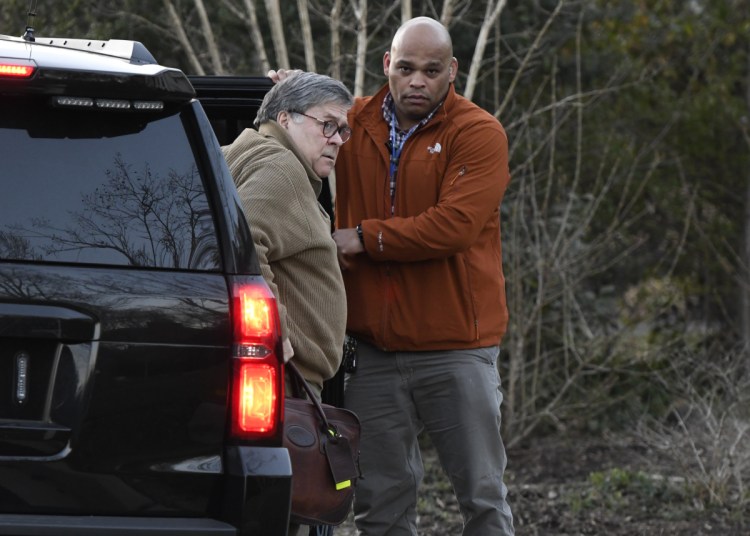 Attorney General William Barr, left, arrives home in McLean, Va., on Saturday. He and his team are poring over the Mueller report.