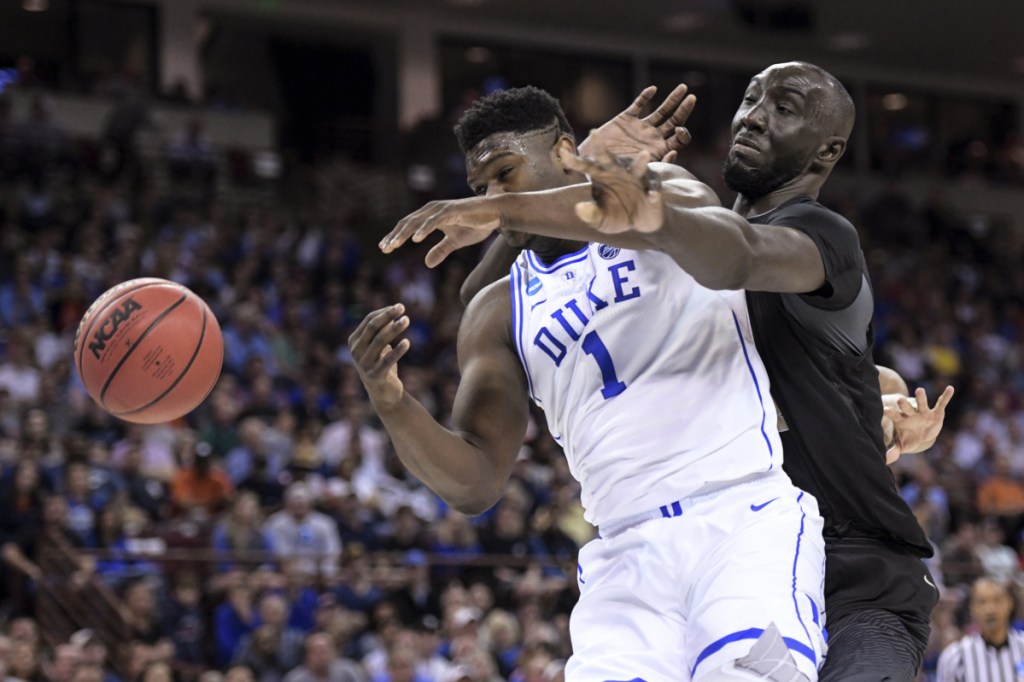 Central Florida center Tacko Fall defends Duke forward Zion Williamson during their second-round game Sunday in Columbia, South Carolina.