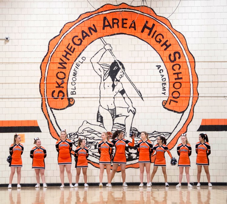 Skowhegan Area High School cheerleaders stand on Jan. 15 beneath the Indian mural on the wall of the school's gymnasium.