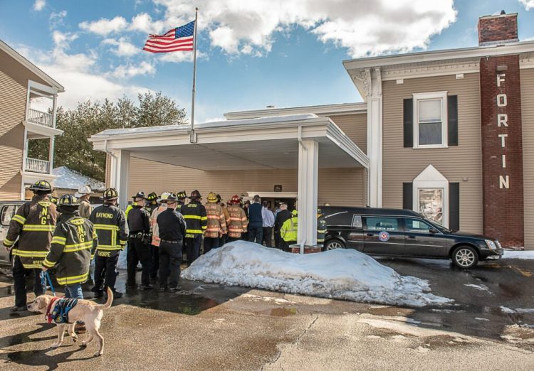 Firefighters in turnout gear arrive in Lewiston to escort the body of Oxford Fire Chief Gary Sacco into the Fortin funeral home Monday. 
