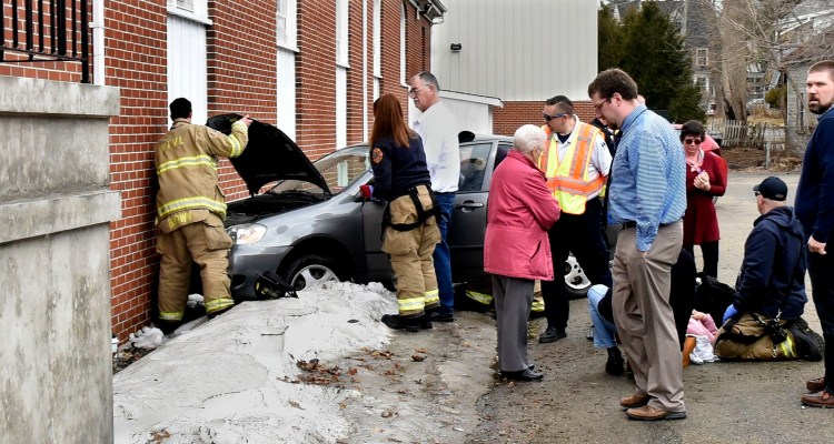 A conscious woman driver is treated at the scene after her vehicle struck the side of the Blessed Hope Church in Waterville on Sunday.
