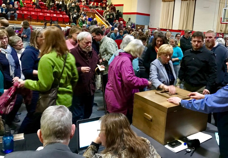Gov. Janet Mills, right center, casts her ballot along with other Farmington residents who voted on whether to support the NECEC project at the annual Town Meeting on Monday. The vote was 262-102 to oppose the project.