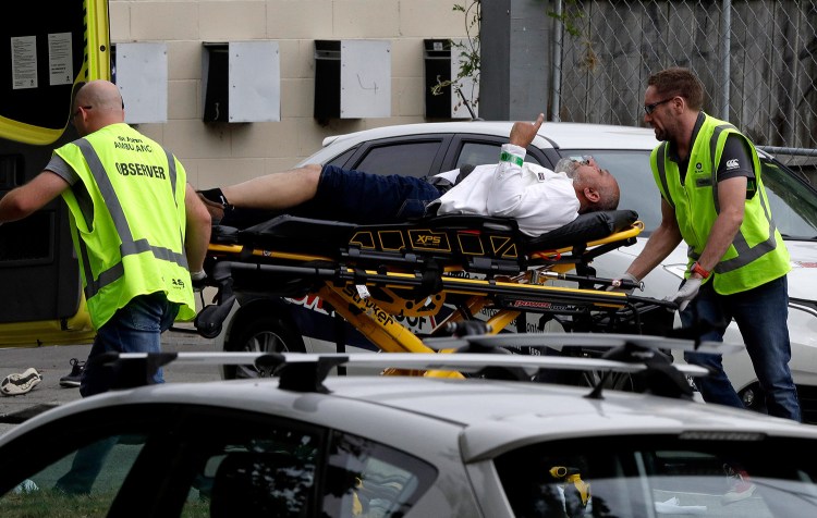 Ambulance workers take a man from outside the mosque in Christchurch, New Zealand, where a witness said many people were killed Friday in a mass shooting.